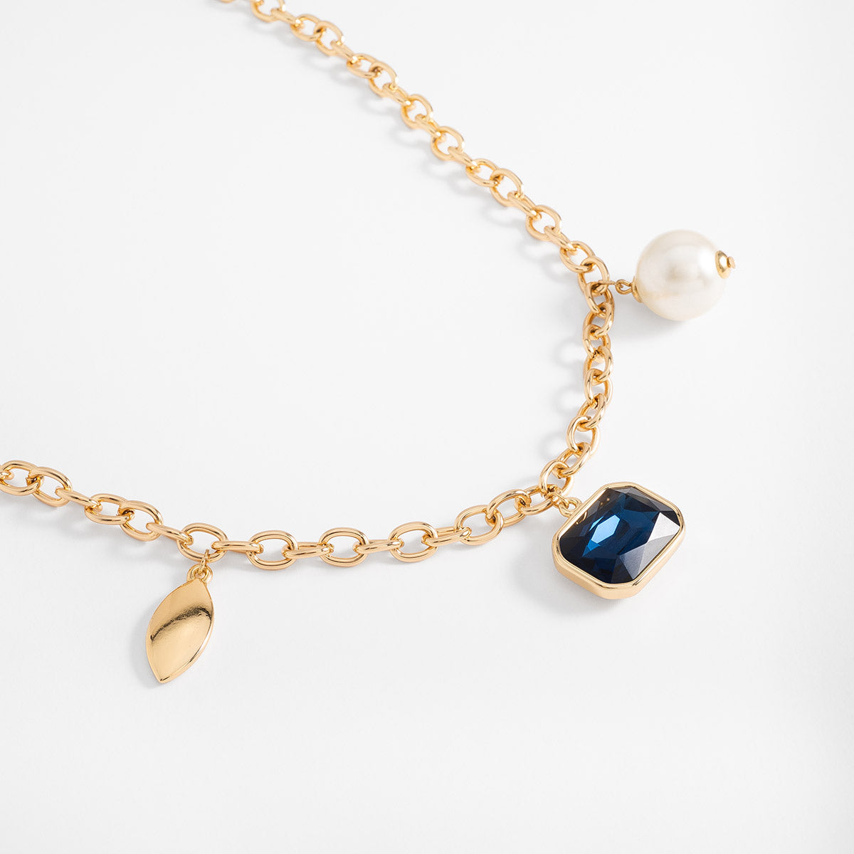 Collar en baño de oro con dije azul y perla sintética