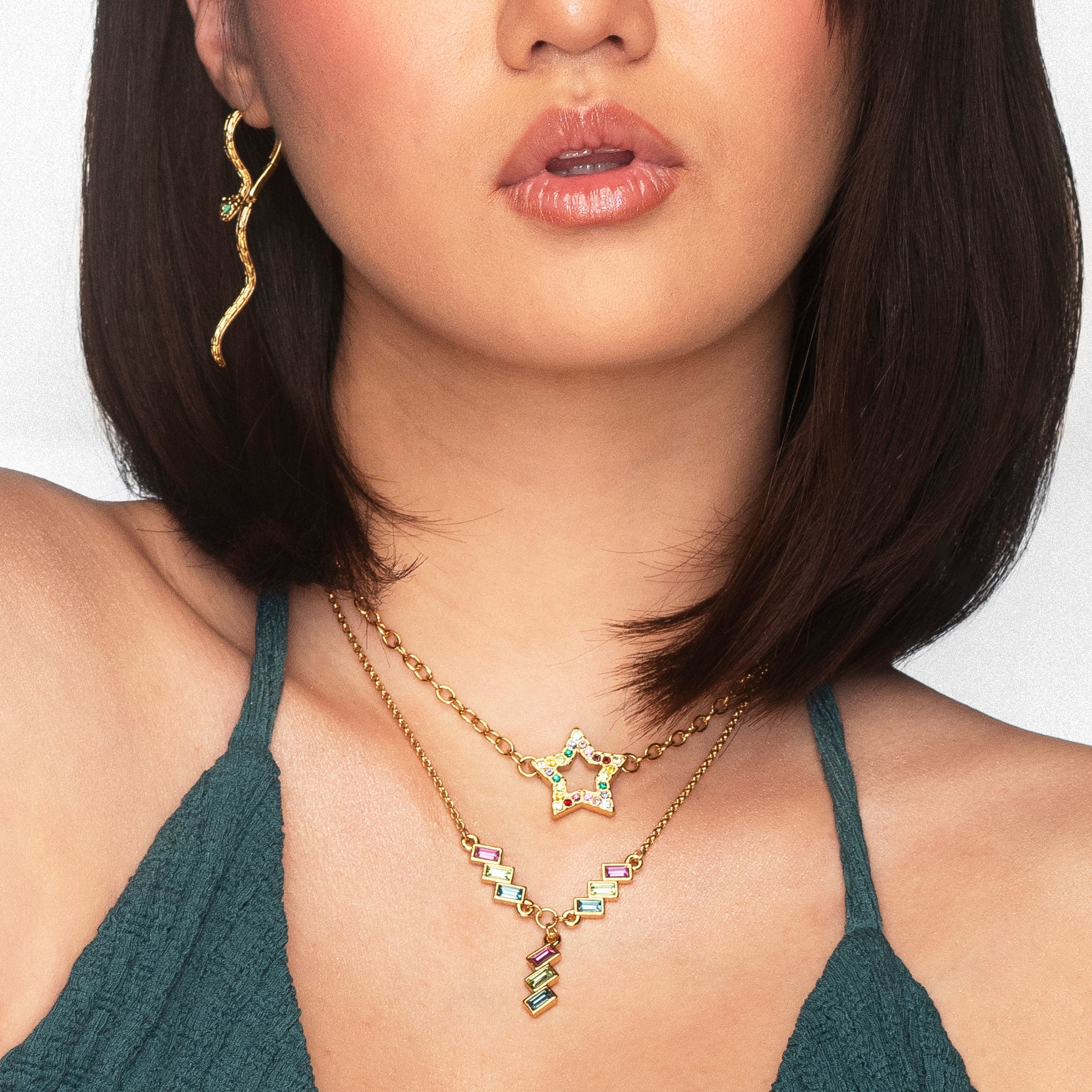 Aretes largos de serpiente con baño de oro y gemas Diamonice verdes.